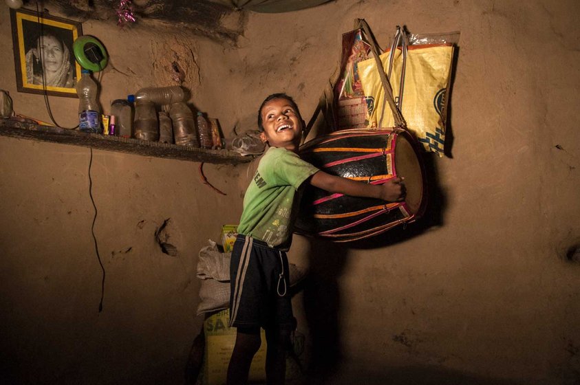 A boy plays with the dholak drum