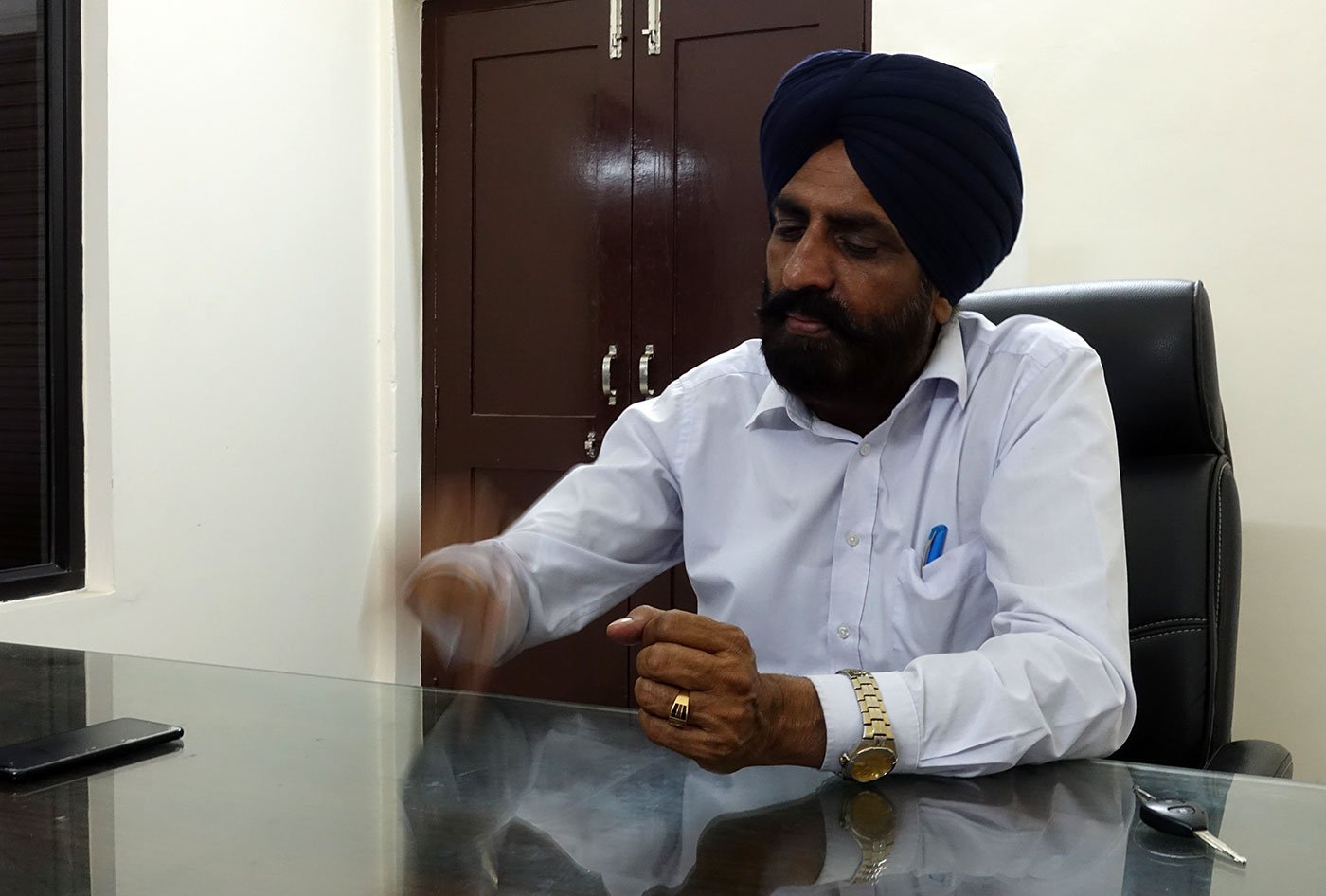 A man sitting at a table in a blue turban