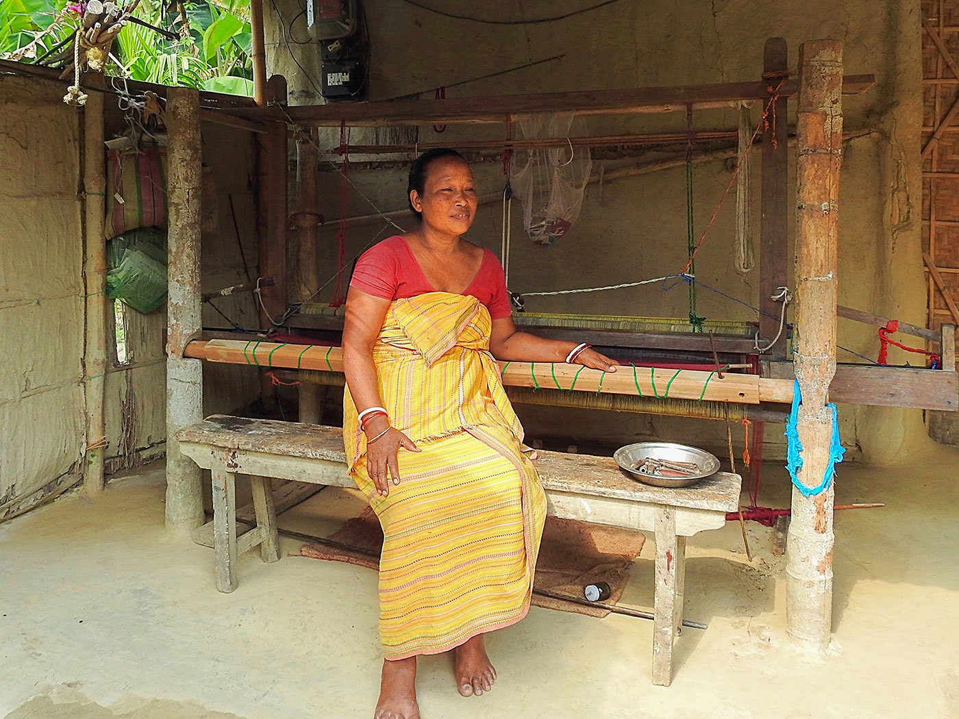 Sama seated at her bamboo pedal loom, 