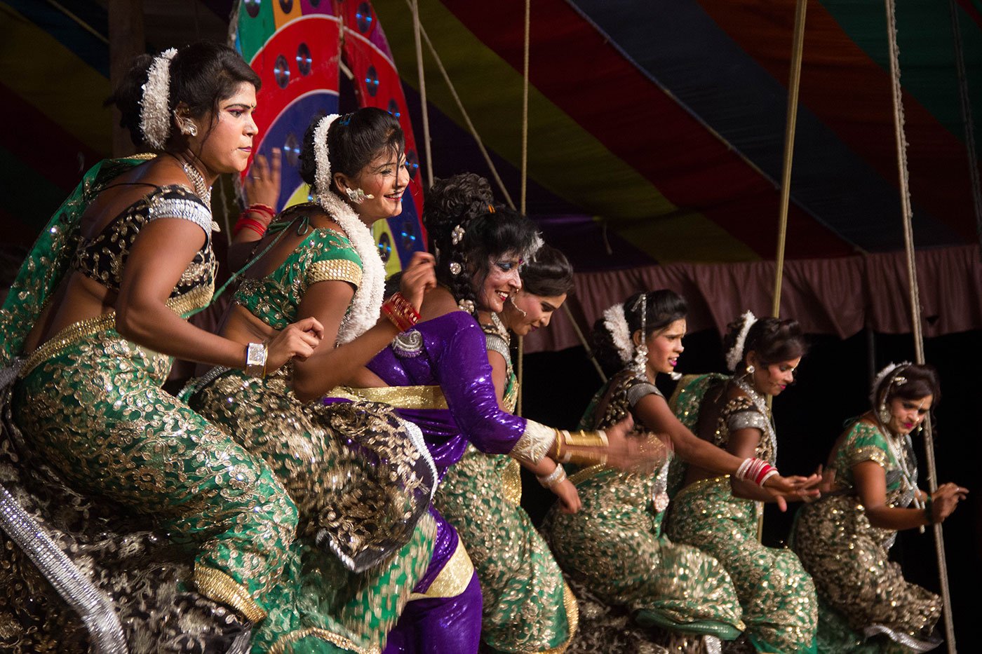 Women in saris dancing on a stage at a tamasha performance