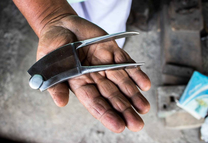 Dilawar Shikalgar – here with and his son Salim – uses a hammer to shape an iron block into a nut cutter or adkitta of distinctive design and durability

