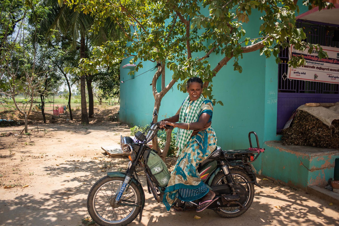 Adaikalaselvi is parking her bike under the sweet guava tree