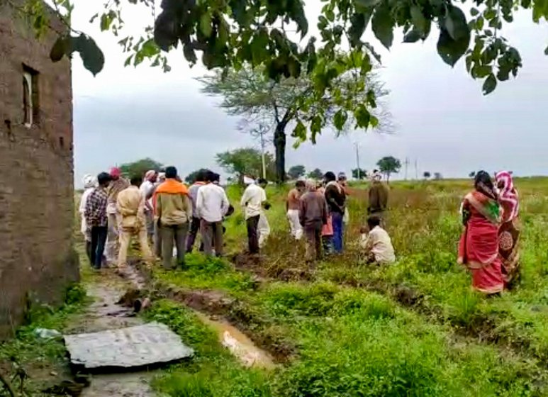 A crowd examining the damage the day after the attack on the Chavan family