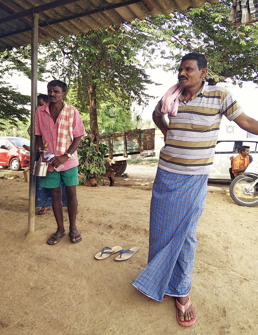 Two men standing under a roof