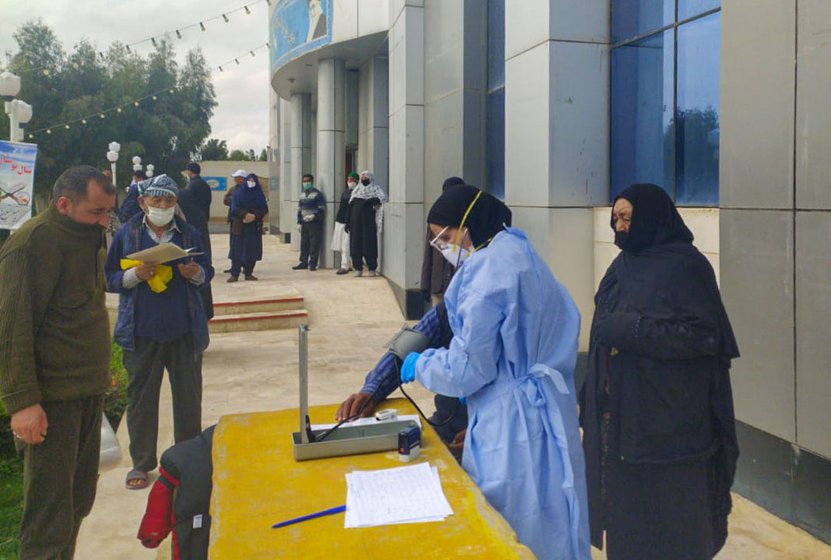 Left: An Iranian medical team examining Ladakhi pilgrims outside their hotel in Qom. Right: Rations being distributed in Kargil's Sankoo village

