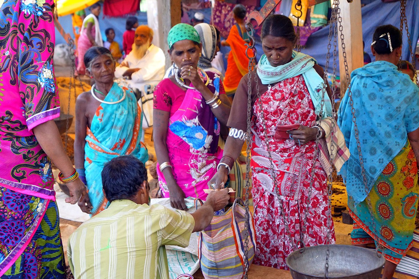 Women sell forest produces, including mahua flowers and lac  (a natural resin)  to a trader.  