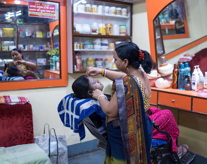 Pramila threading a customer's eyebrows