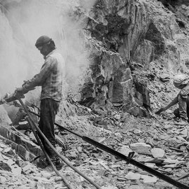 Man drilling into the mountainside in Ladakh for a road