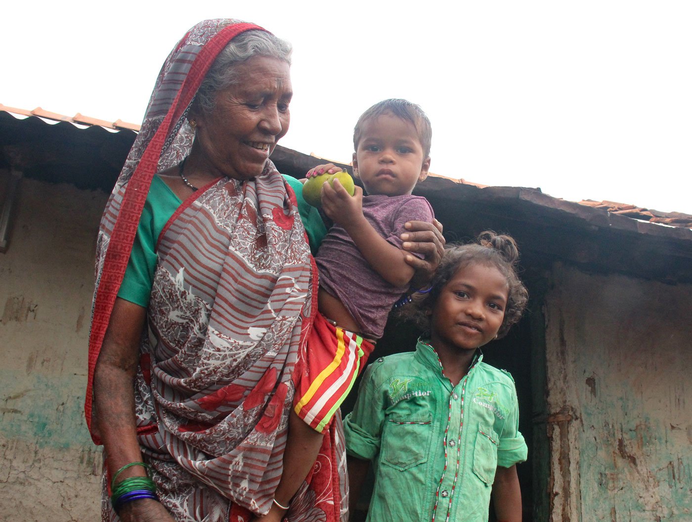 Charku with two of her great grandkids: at least half of the babies born in Bortyakheda over the past three decades had Charku present at the time of their birth, and she has delivered her own grandchildren and a great-grandchild