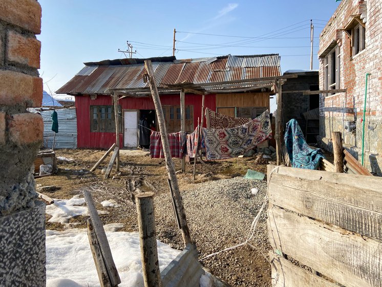 Left: Younger son Ali says, 'My father doesn’t have money, how can I go to school?' Right: The family's tin home behind Arshid's father’s house