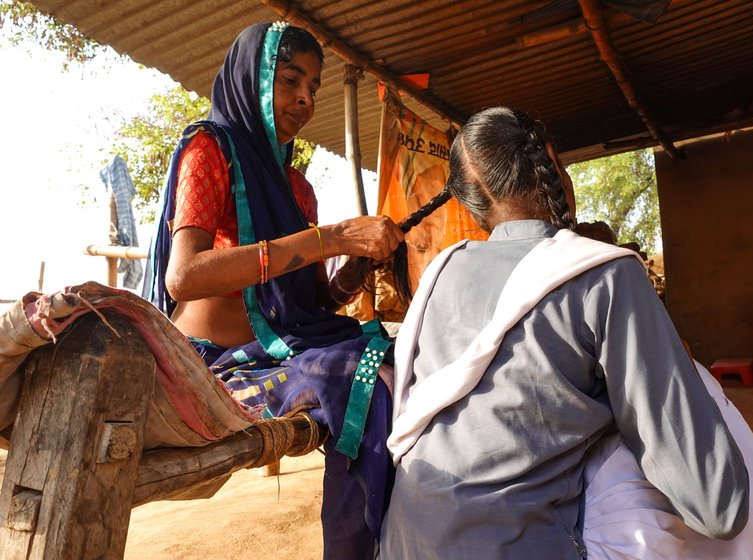 Poonam Devi braids Kiran’s hair before she goes to school in the morning.