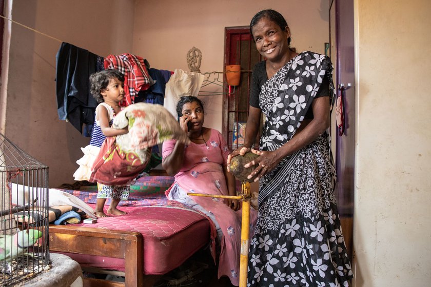 Left: At home, Thankamma is greeted by her daughter Karthika, grandchild Vaishnavi and a pet parrot, Thathu.