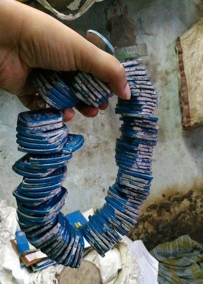 Left: Punching the letters on the token. Centre: One set of an order of 1,000 tokens that was not picked by a customer. Right: Azeem shows us how a batch of the tokens will be arranged inside the peti