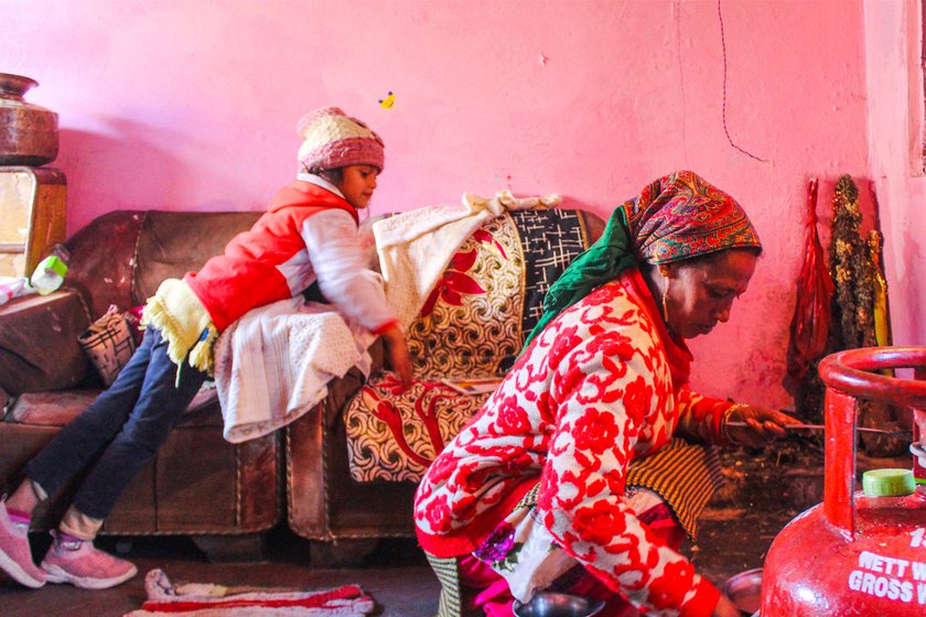 Ayesha looks on as her mother Gauri makes chuni roti for the Chunyatyar festival