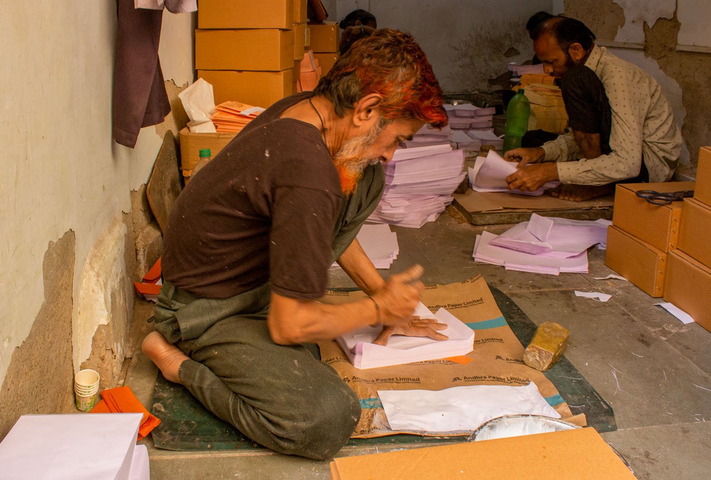 Mohammad Ilyas Shaikh of Dhruv Envelopes, using his fist on the side flap. He works on 100 envelopes at a time and needs to repeat the same action some 16 times leaving the sides of his palm sore