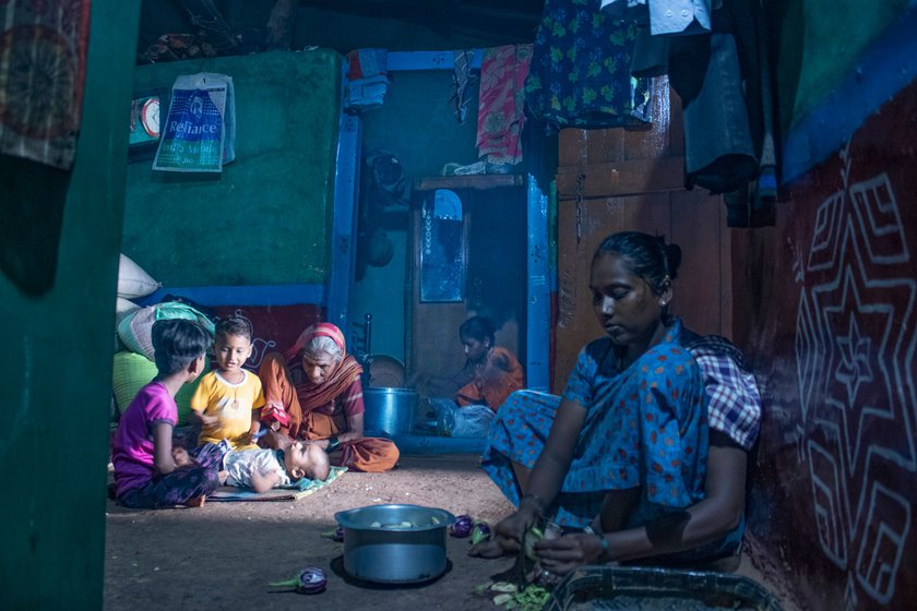 Inside the house, Manjula (at the back) and her relatives cook together and watch over the children