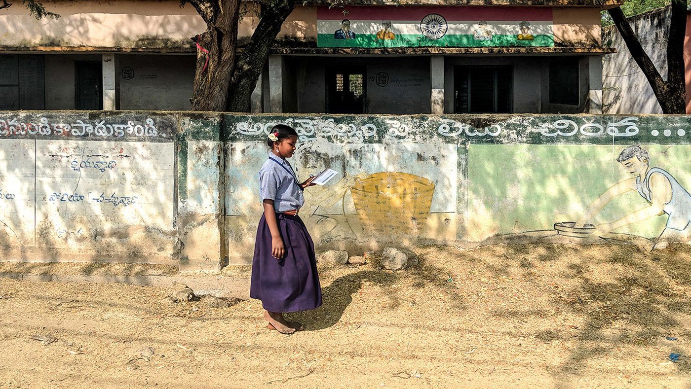 Indu reading outside her school