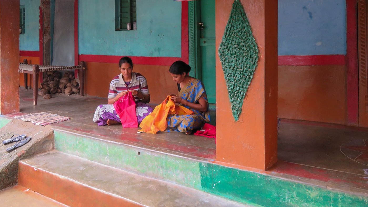 Women sitting in veranda sewing