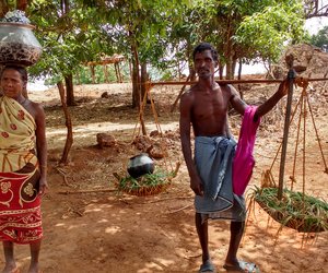 Titibai and Terra Manjhi standing with loads on head and shoulders