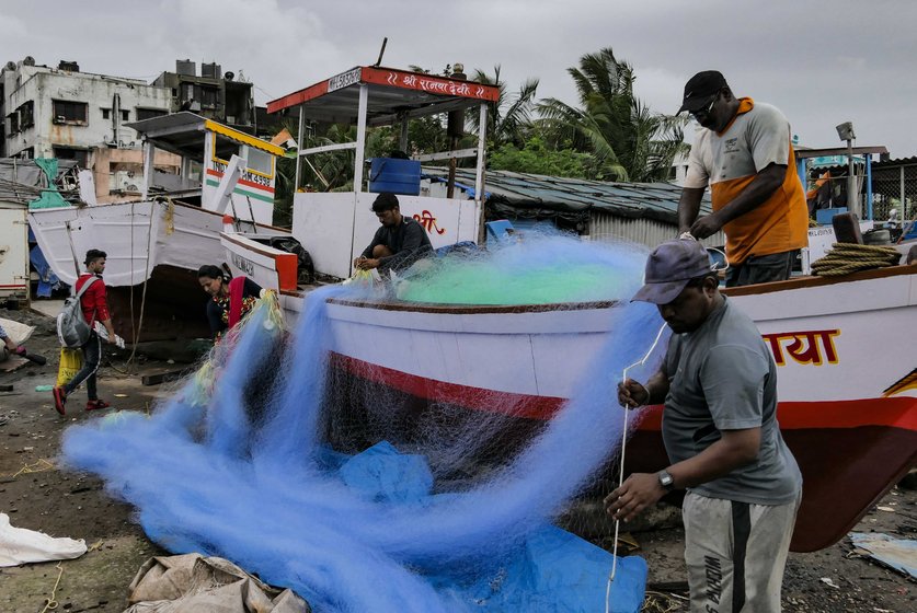 Left: Struggling against a changing tide – fishermen at work at the koliwada. Right: With the fish all but gone from Malad creek and the nearby shorelines, the fishermen of Versova Koliwada have been forced to go deeper into the sea