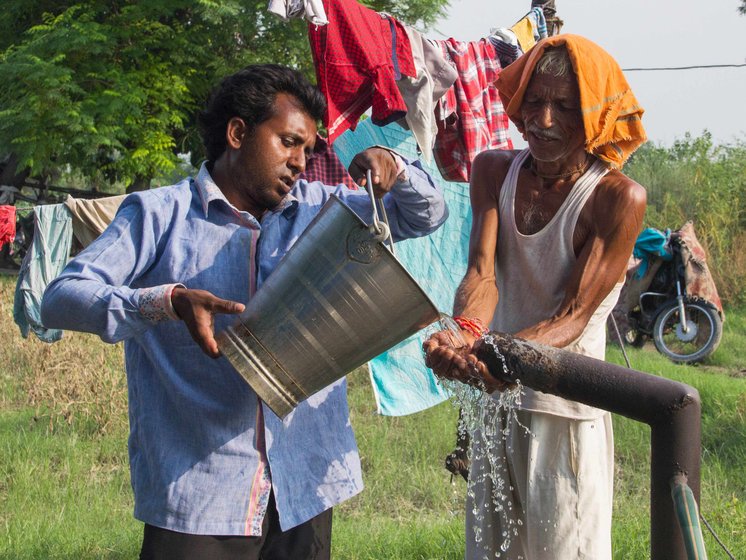 Shiv Shankar and his son Praveen Kumar start the watering process on their field