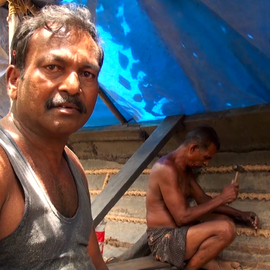 Two boat repairmen at work