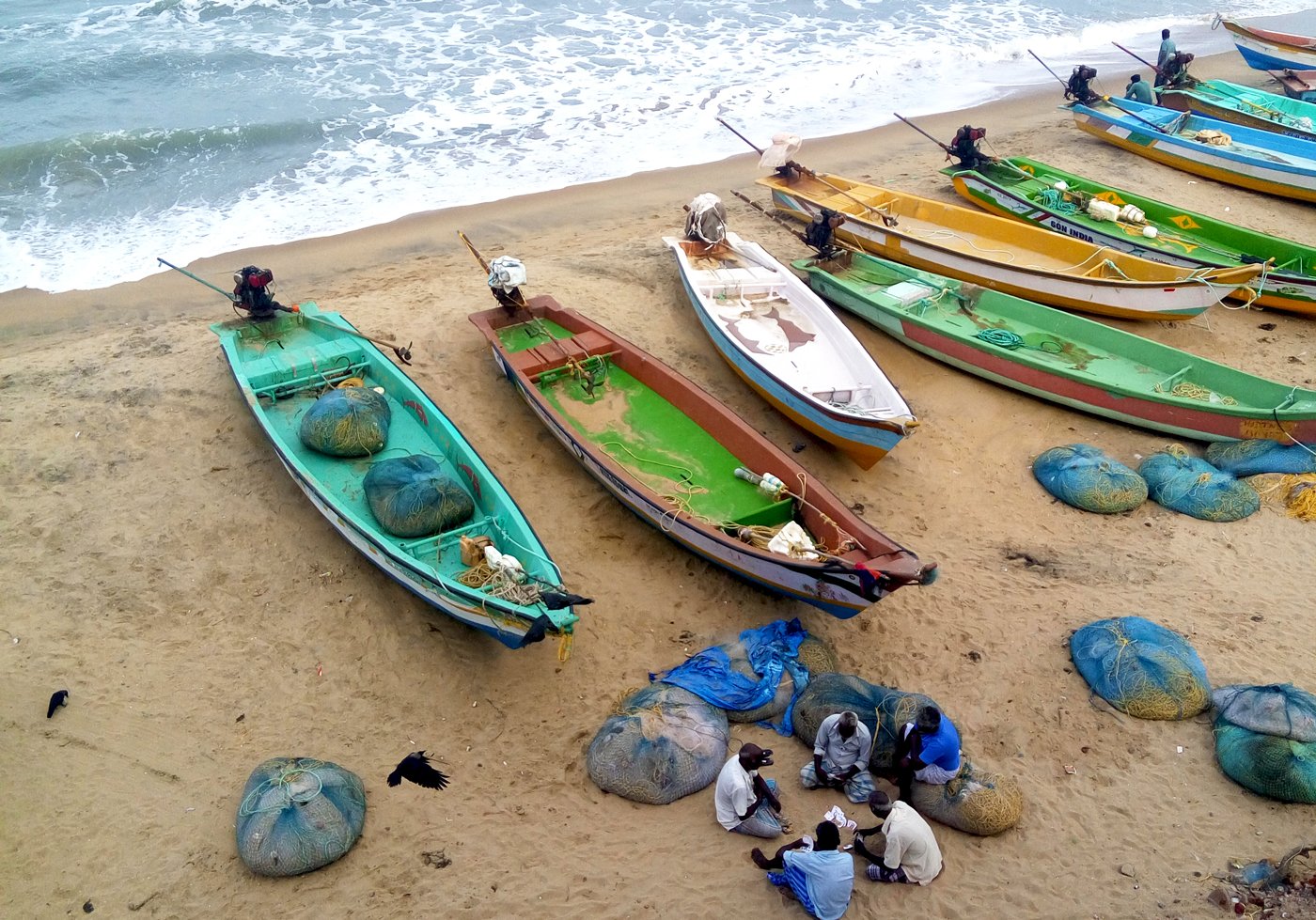 Men playing cards near the shore