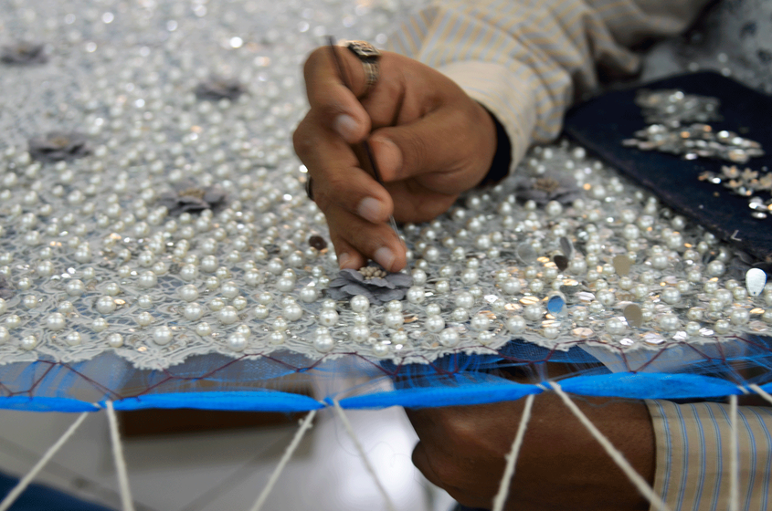 Close up of hand while doing zari work. 