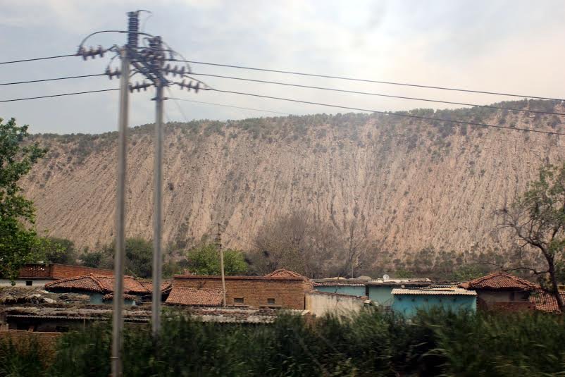 Long shot of village rooftops with mountain in background