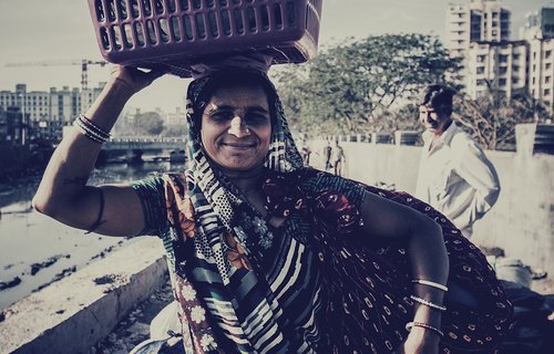 Woman carrying basket full of utensils