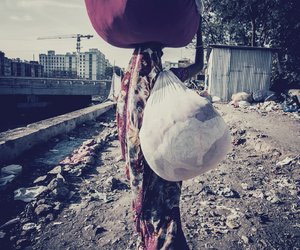 Woman carrying sacks of clothes 